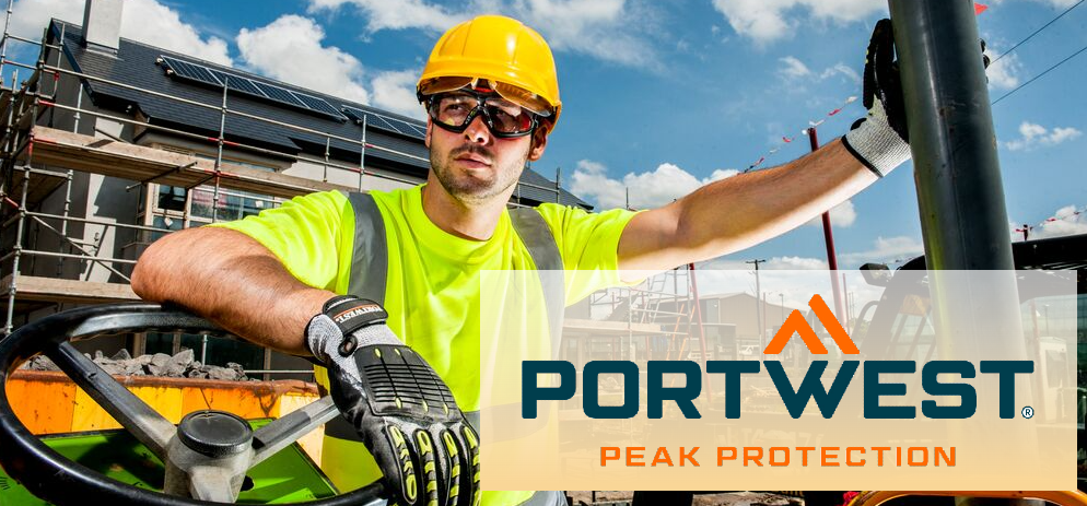 Operaio edile con occhiali di sicurezza, casco e guanti in un cantiere; in primo piano, il logo Portwest con lo slogan "Peak Protection".