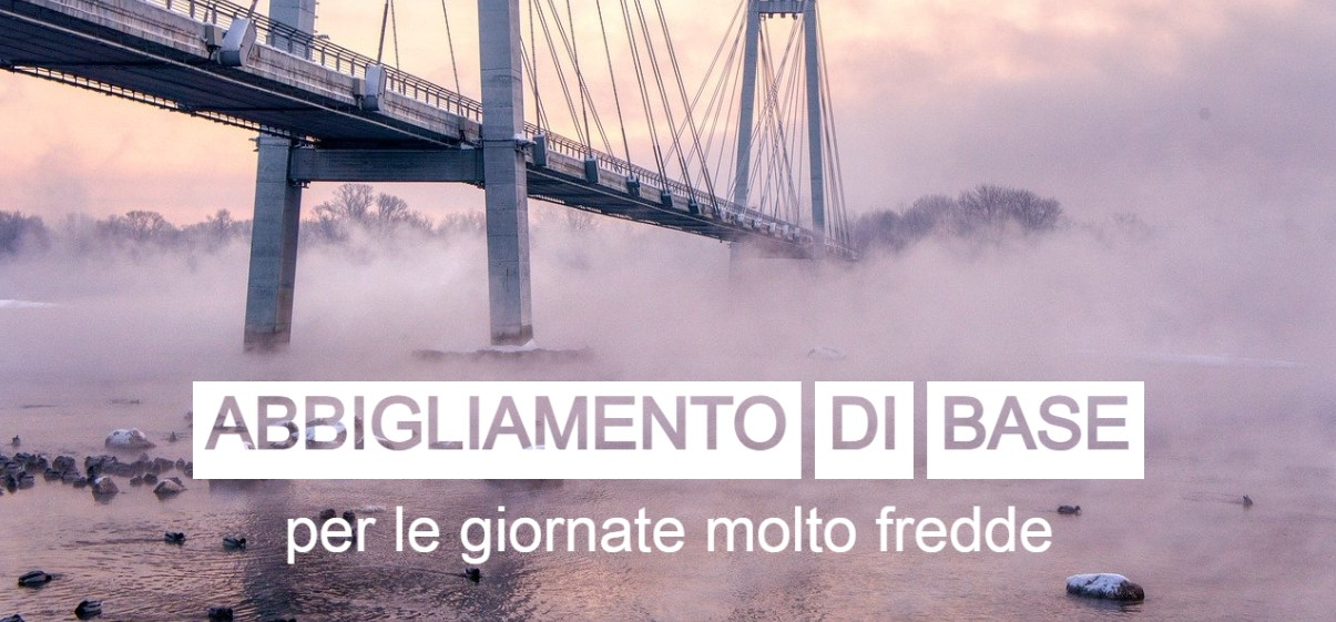 Un ponte sospeso che attraversa un fiume nebbioso e ghiacciato, catturato all'alba. Il testo "Biancheria intima per giornate lavorative molto fredde" è posizionato sopra l'immagine in grandi lettere bianche. La scena trasmette un'atmosfera invernale e gelida.