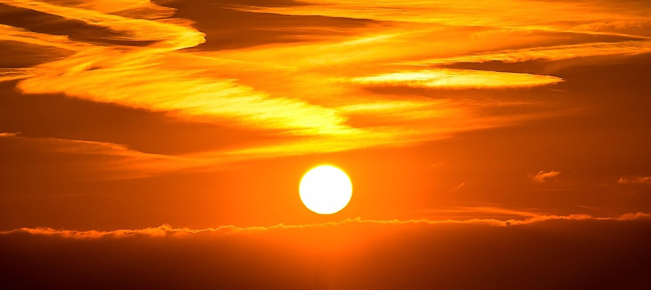 Il sole tramonta contro un cielo rosso fuoco e si può quasi percepire il calore.